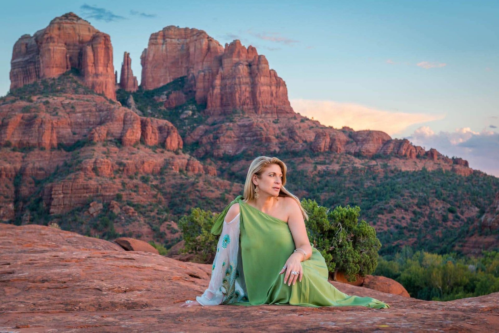 Maria Therase in a green dress on the red rocks of Sedona at sunset
